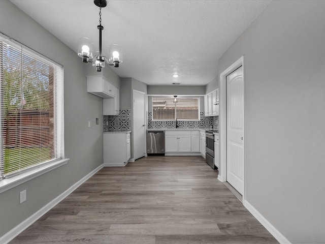 kitchen with plenty of natural light, white cabinets, and appliances with stainless steel finishes