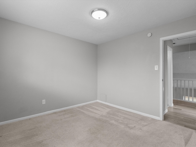 unfurnished room featuring light carpet and a textured ceiling