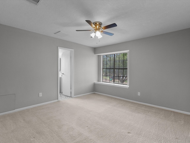 carpeted empty room with ceiling fan and a textured ceiling