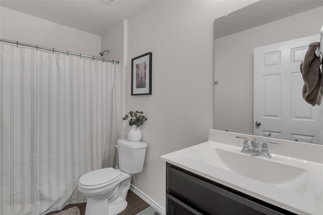 bathroom featuring hardwood / wood-style flooring, vanity, toilet, and walk in shower