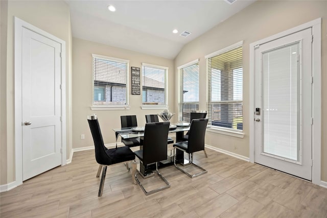 dining area featuring light hardwood / wood-style floors and vaulted ceiling