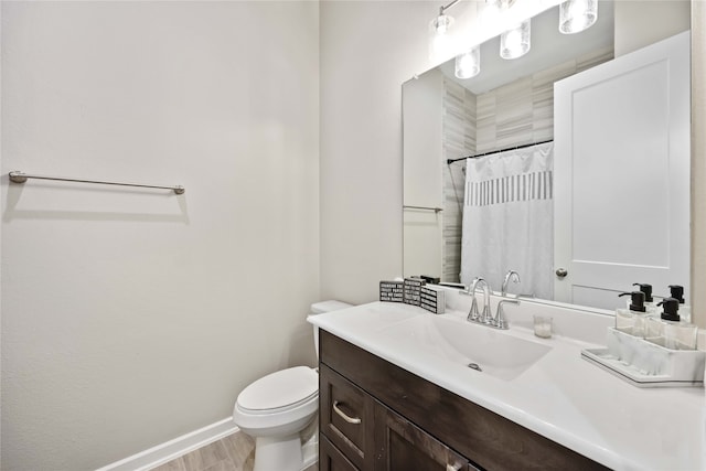 bathroom with curtained shower, vanity, hardwood / wood-style flooring, and toilet