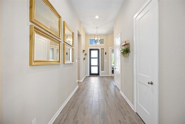 doorway featuring light hardwood / wood-style flooring and an inviting chandelier