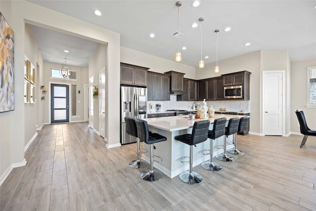 kitchen with a healthy amount of sunlight, decorative light fixtures, and appliances with stainless steel finishes