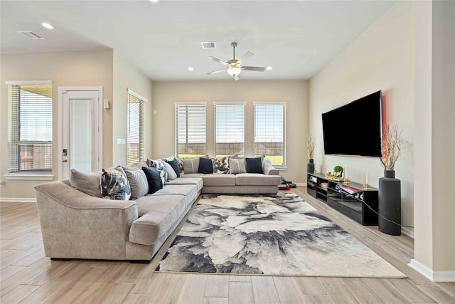 living room featuring plenty of natural light, ceiling fan, and light wood-type flooring