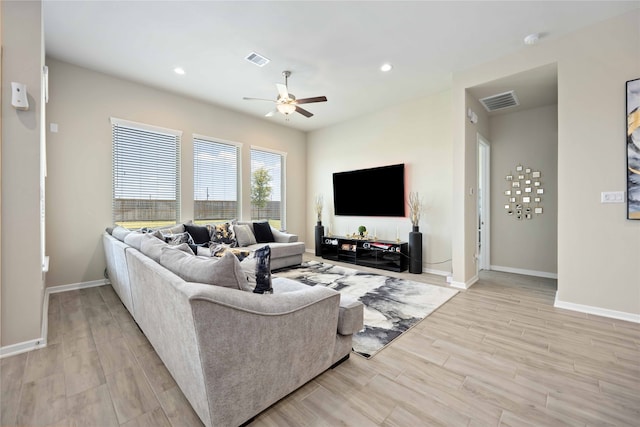 living room featuring ceiling fan and light hardwood / wood-style flooring