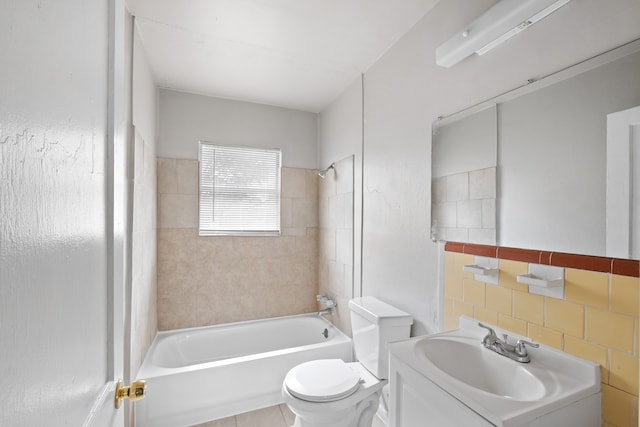 full bathroom with tile patterned flooring, toilet, vanity, tile walls, and tiled shower / bath