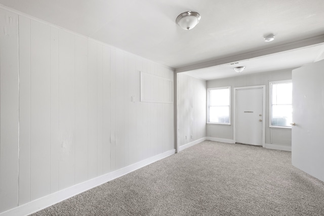 empty room with carpet flooring and wooden walls