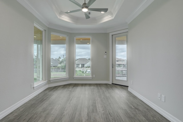 unfurnished room with a raised ceiling, crown molding, ceiling fan, and hardwood / wood-style flooring