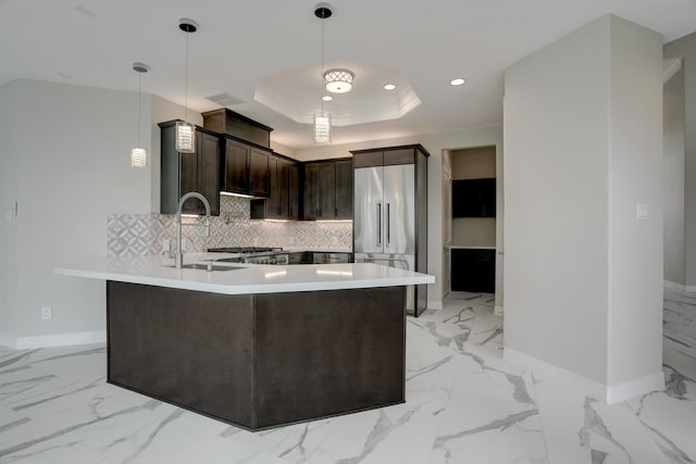 kitchen featuring pendant lighting, sink, decorative backsplash, appliances with stainless steel finishes, and dark brown cabinetry