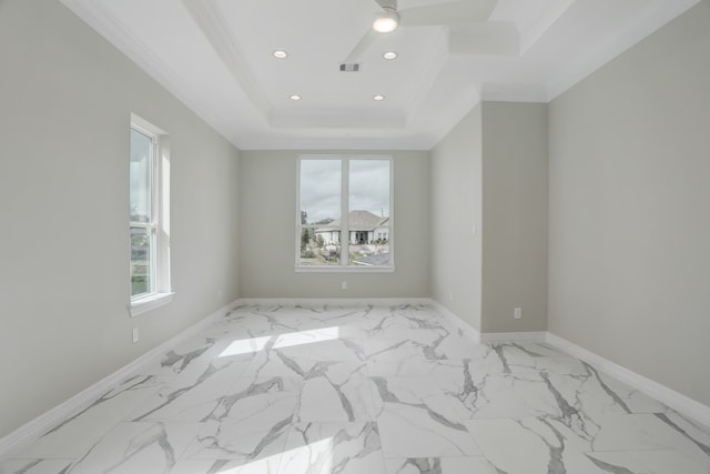 empty room featuring ceiling fan, ornamental molding, and a tray ceiling