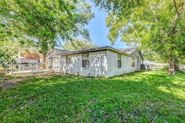 view of side of property featuring central air condition unit and a lawn