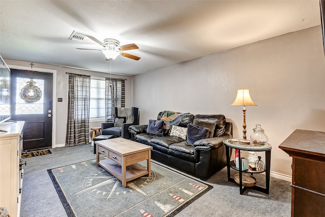 living room featuring ceiling fan and dark colored carpet