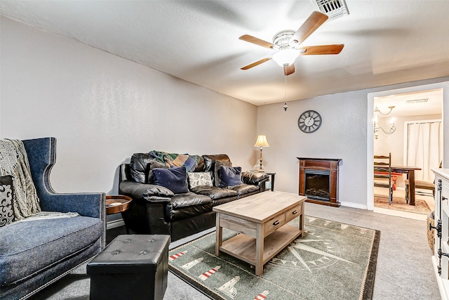 living room featuring ceiling fan with notable chandelier and dark carpet