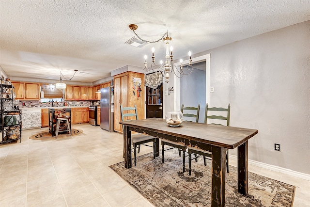 tiled dining space featuring a textured ceiling and an inviting chandelier