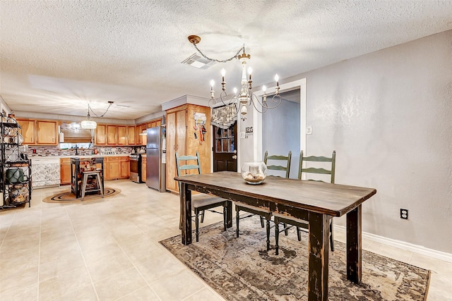 1215 Esther St, Kemah, TX 77565 - dining space with a chandelier, a textured ceiling, and baseboards
