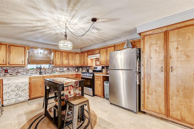 1215 Esther St, Kemah, TX 77565 - kitchen featuring stainless steel appliances, under cabinet range hood, light countertops, a sink, and light tile patterned flooring