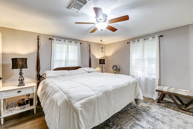 1215 Esther St, Kemah, TX 77565 - bedroom featuring wood finished floors, a textured ceiling, and a ceiling fan