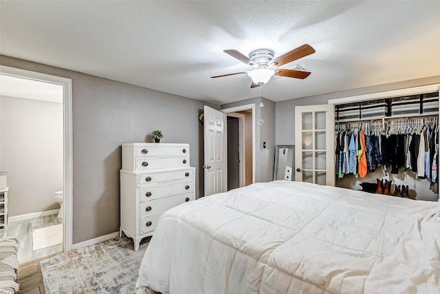 1215 Esther St, Kemah, TX 77565 - bedroom with a closet, wood finished floors, baseboards, a ceiling fan, and ensuite bath