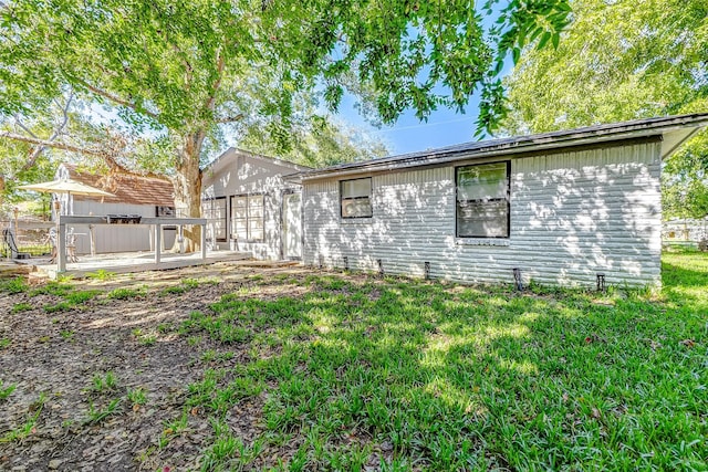 1215 Esther St, Kemah, TX 77565 - rear view of house with a lawn and a wooden deck