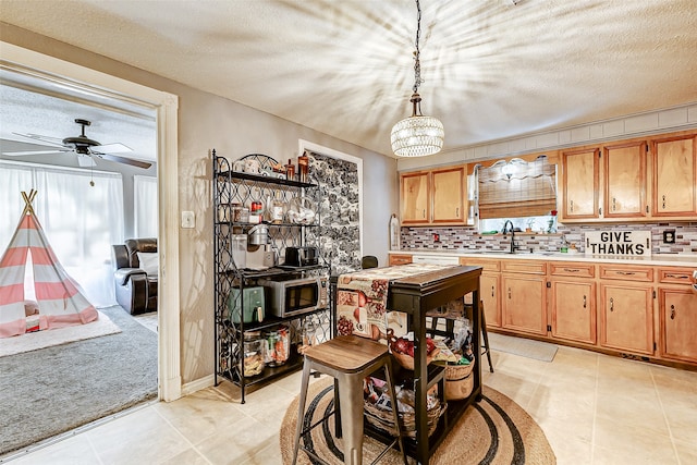 kitchen with tasteful backsplash, light tile patterned floors, hanging light fixtures, and a textured ceiling