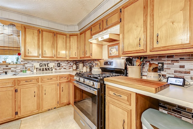 1215 Esther St, Kemah, TX 77565 - kitchen featuring stainless steel range with gas cooktop, under cabinet range hood, decorative backsplash, light countertops, and a textured ceiling