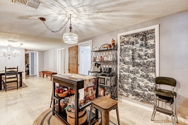 tiled dining room featuring a chandelier and a textured ceiling