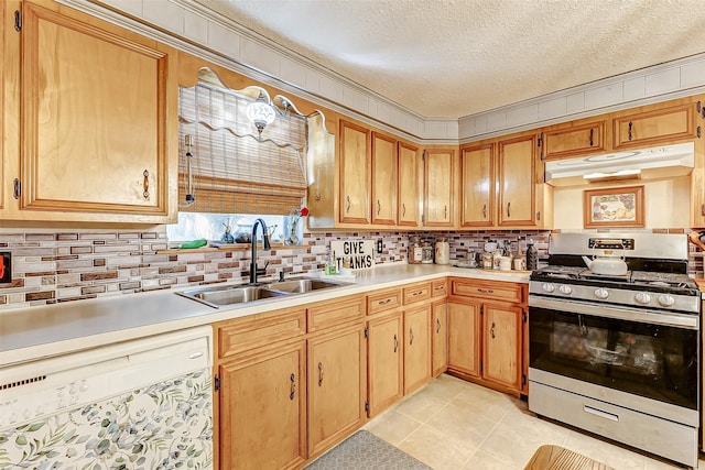 1215 Esther St, Kemah, TX 77565 - kitchen featuring under cabinet range hood, stainless steel range with gas cooktop, a sink, white dishwasher, and a textured ceiling