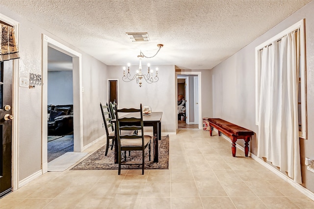 dining room featuring light tile patterned flooring, a textured ceiling, and a chandelier