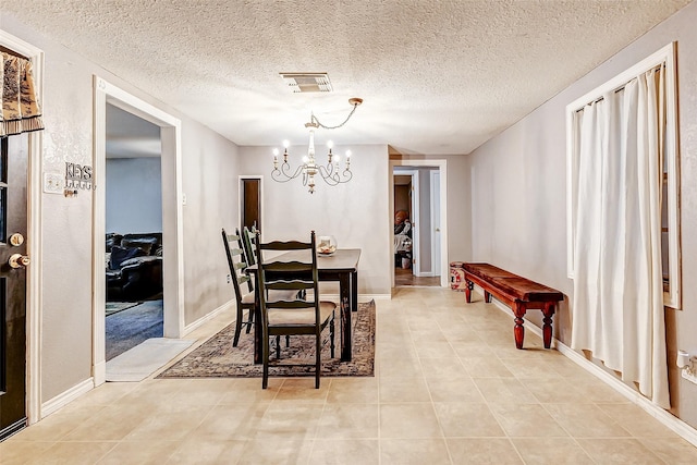 1215 Esther St, Kemah, TX 77565 - dining area featuring a chandelier, a textured ceiling, and light tile patterned floors