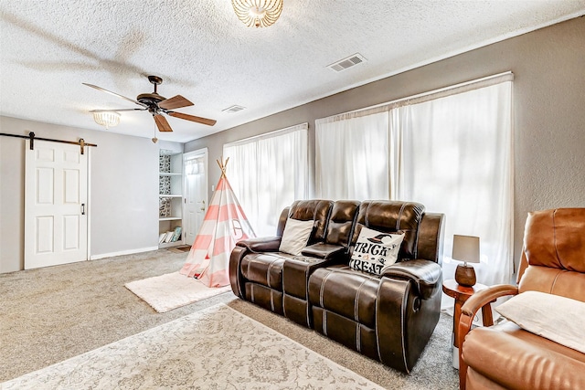 1215 Esther St, Kemah, TX 77565 - living area featuring a barn door, ceiling fan, carpet floors, a textured ceiling, and baseboards