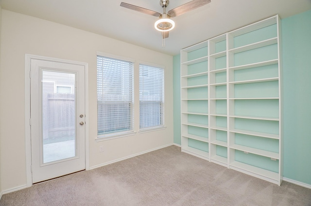 carpeted empty room featuring ceiling fan