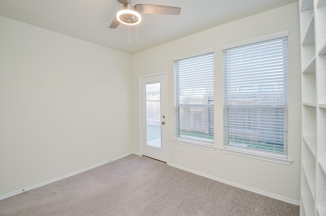 carpeted spare room with ceiling fan