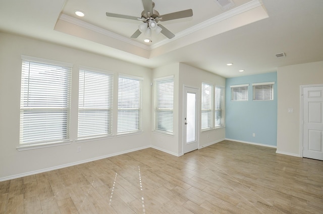 unfurnished room featuring a tray ceiling and a healthy amount of sunlight