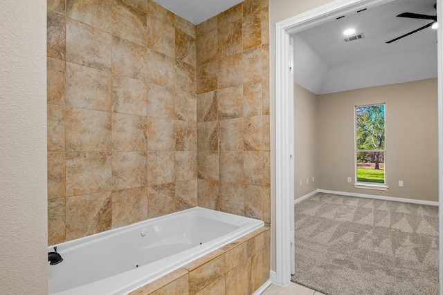 bathroom with tiled tub and ceiling fan