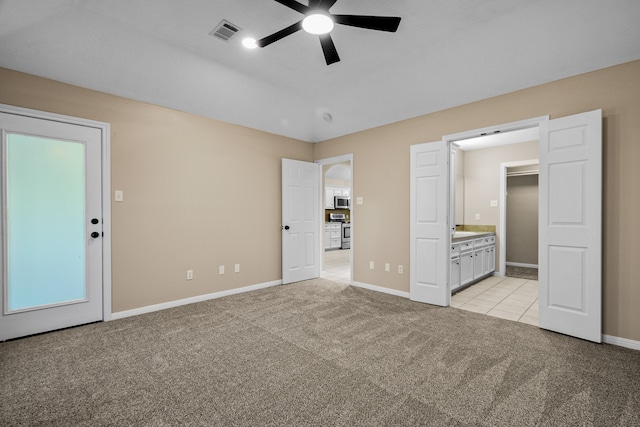 unfurnished bedroom with light carpet, ensuite bathroom, and ceiling fan