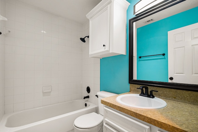 full bathroom with vanity, tiled shower / bath combo, and toilet