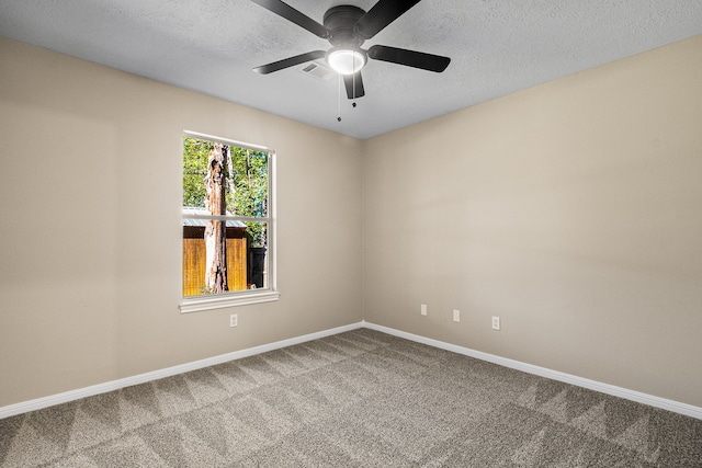 spare room featuring ceiling fan, carpet, and a textured ceiling