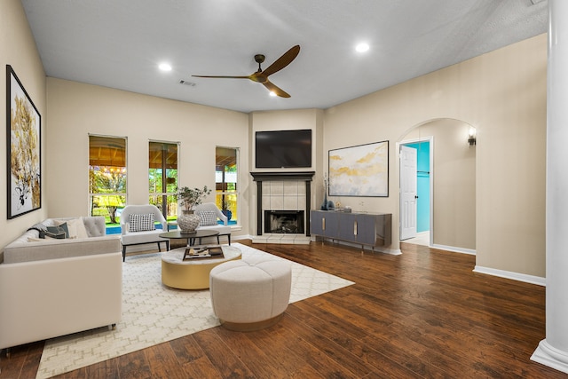 living room with a fireplace, ceiling fan, and hardwood / wood-style floors