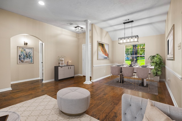 interior space featuring dark hardwood / wood-style floors, ornate columns, and lofted ceiling