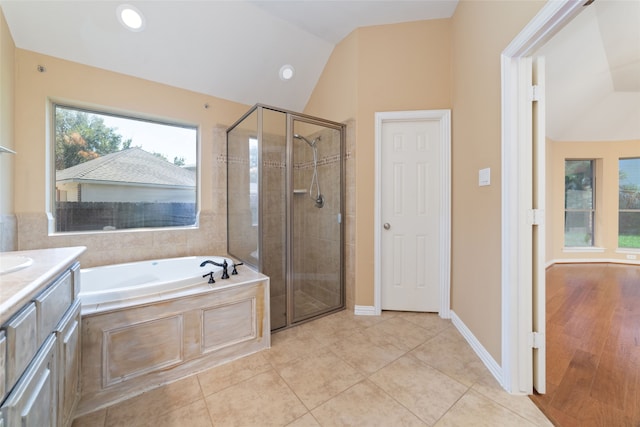 bathroom with tile patterned floors, vanity, plus walk in shower, and vaulted ceiling