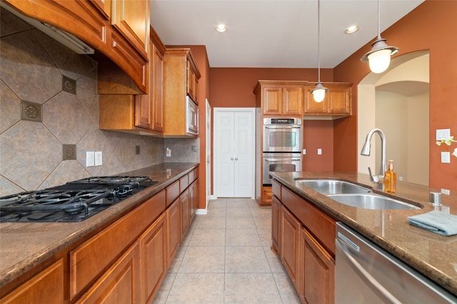 kitchen featuring sink, decorative light fixtures, decorative backsplash, light tile patterned flooring, and appliances with stainless steel finishes