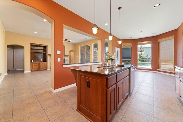 kitchen featuring sink, stainless steel dishwasher, pendant lighting, a kitchen island with sink, and light tile patterned floors