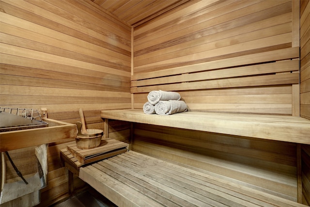 view of sauna featuring wood ceiling and wooden walls