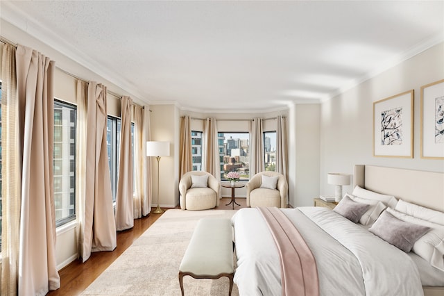 bedroom with light hardwood / wood-style floors and ornamental molding