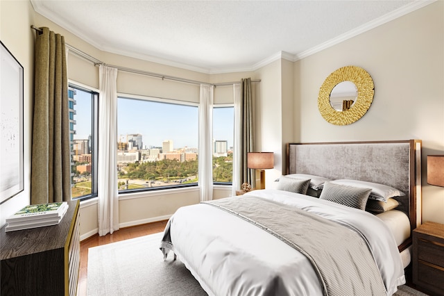 bedroom featuring hardwood / wood-style flooring, ornamental molding, and a textured ceiling