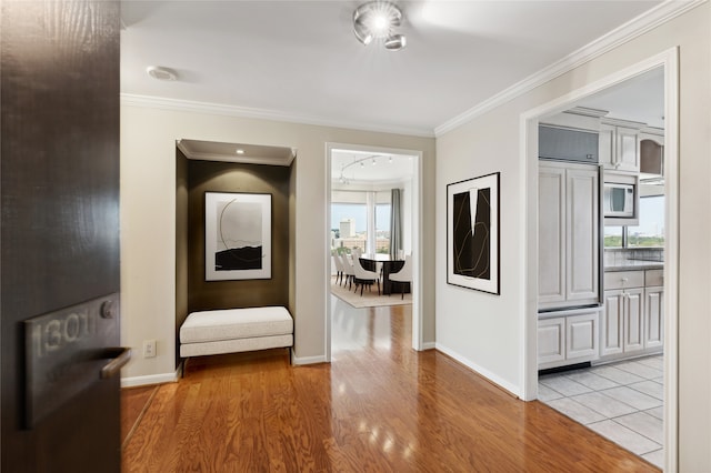 hall featuring light hardwood / wood-style flooring and ornamental molding