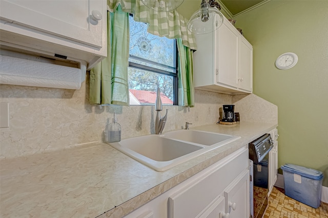 kitchen with tasteful backsplash, white cabinetry, dishwasher, and sink