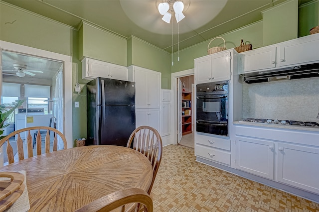 kitchen with white gas cooktop, backsplash, black refrigerator, crown molding, and white cabinetry