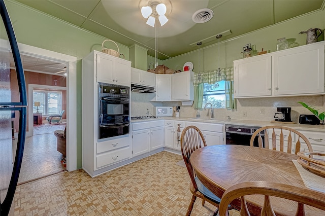 kitchen featuring plenty of natural light, white cabinets, black appliances, and sink